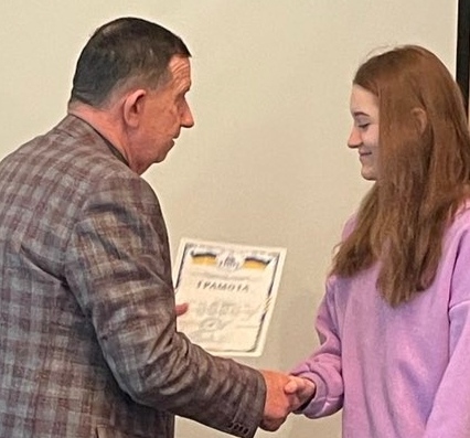 Завідувач кафедри Анатолій Григорук вручає грамоту здобувачці Анні Патрі